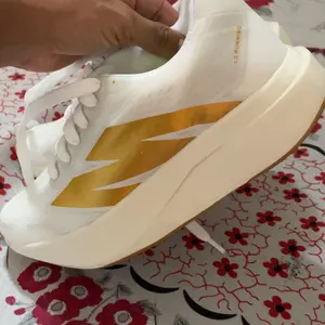 Detalhe do tênis branco e dourado