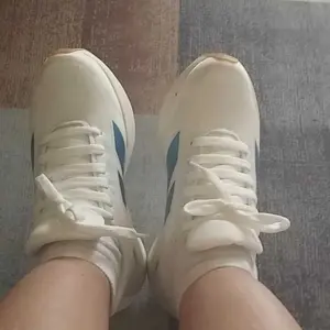 Cliente usando o tênis branco e azul