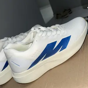 Tênis branco com detalhe azul visto de lado
